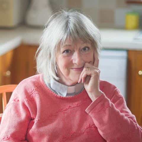 Rev. Maggy Whitehouse sitting in her kitchen