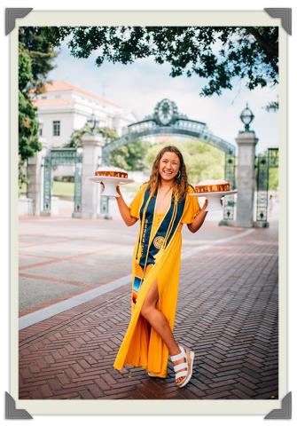 Morales, a young woman with curly, brown hair, stands in front of UC Berkley, holding one cheesecake in each hand, Photo Credit: Will Brinkerhoff