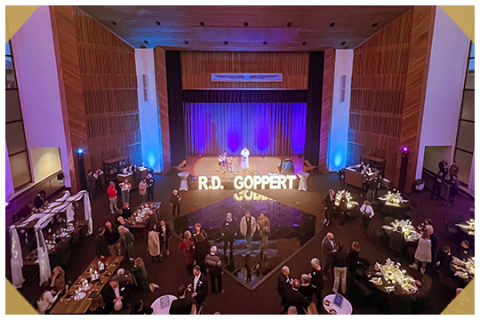 A crowd of people sitting around tables at the R.D. Goppert event center