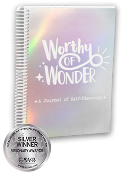 A silver journal with the text "Worthy of Wonder - A journal of self-discovery with a Silver 2022 COVR Award